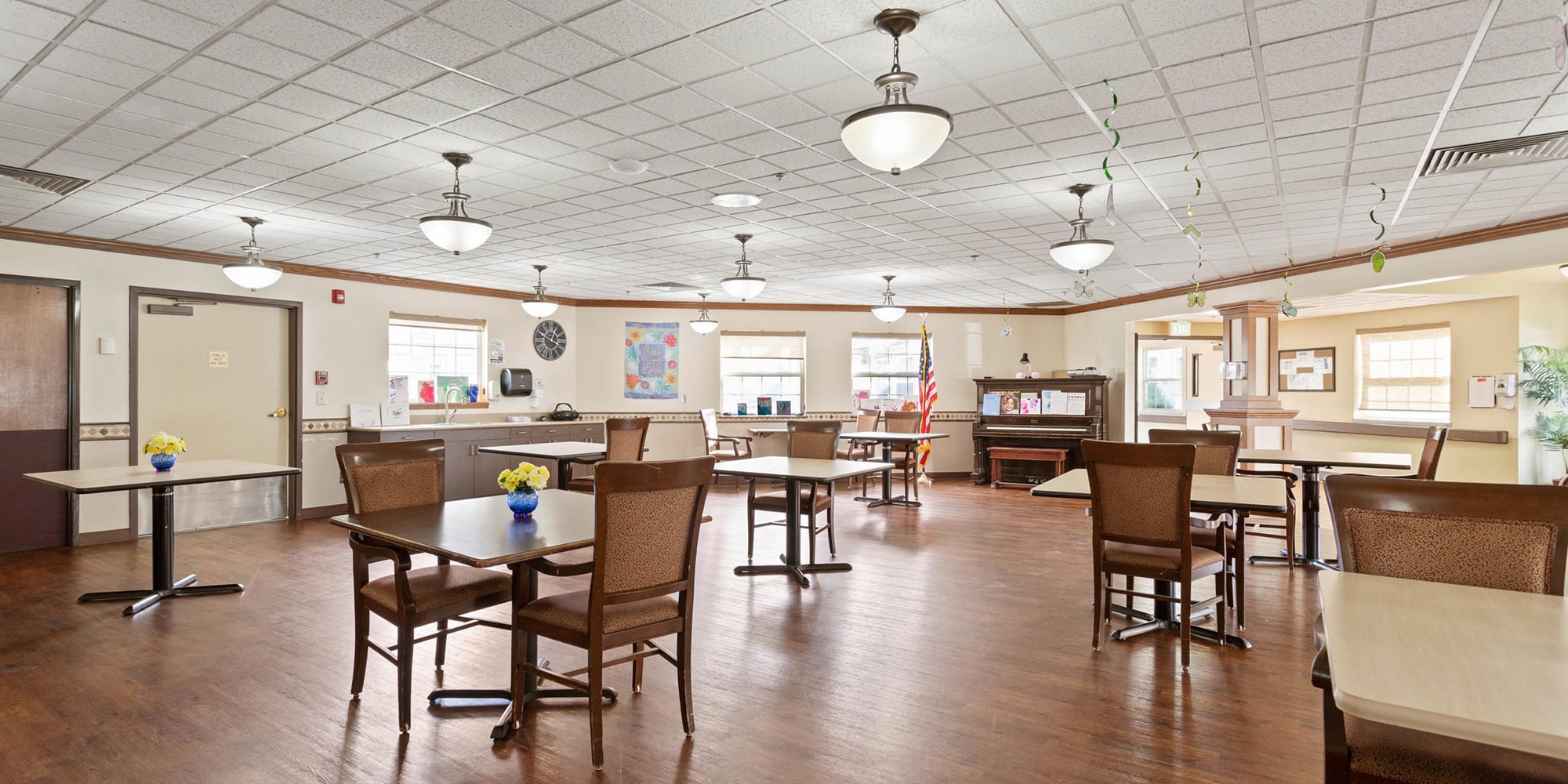 Room with lots of tables and chairs at Sullivan Park Care Center